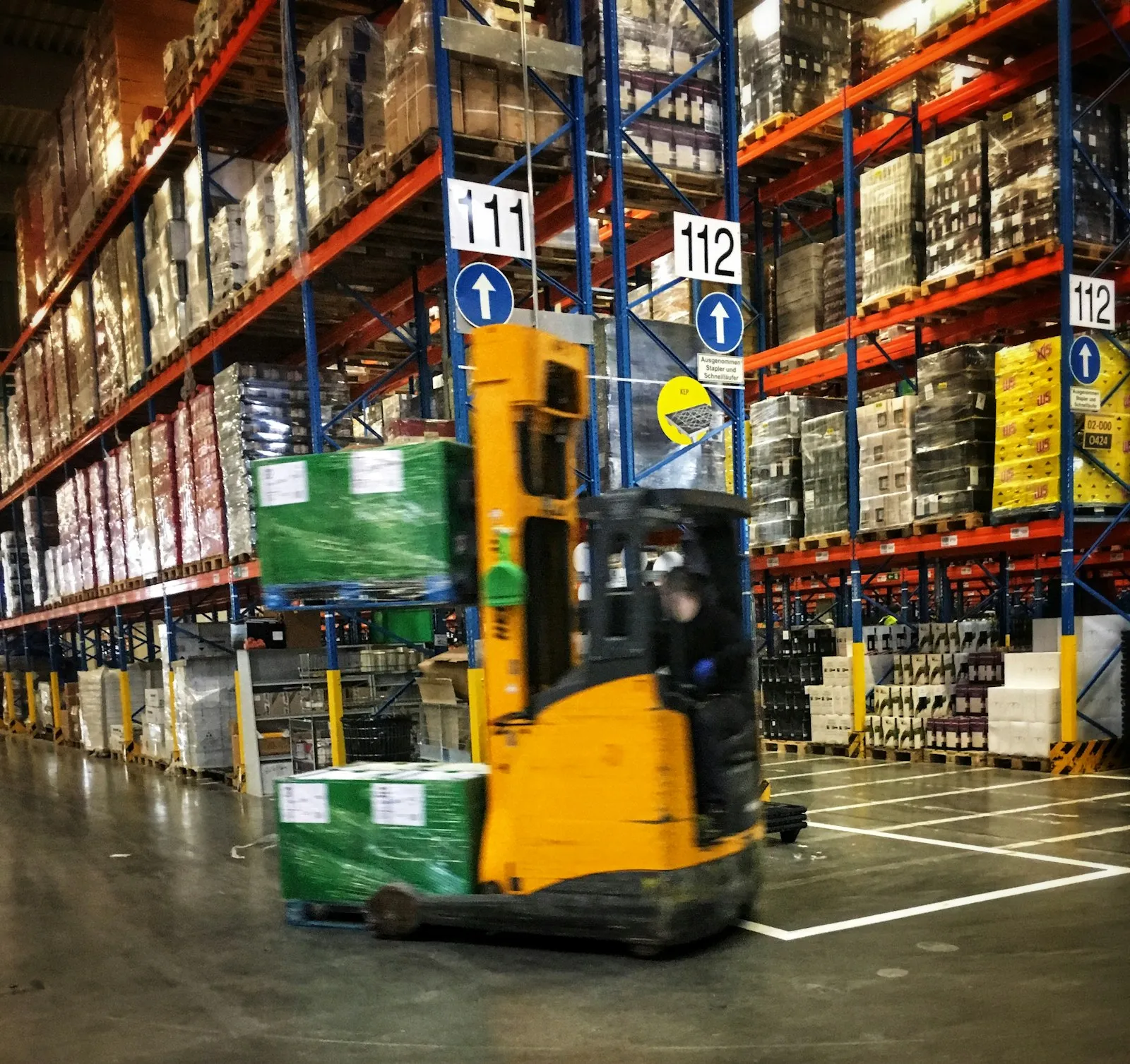 A reach truck working a stocked warehouse aisle